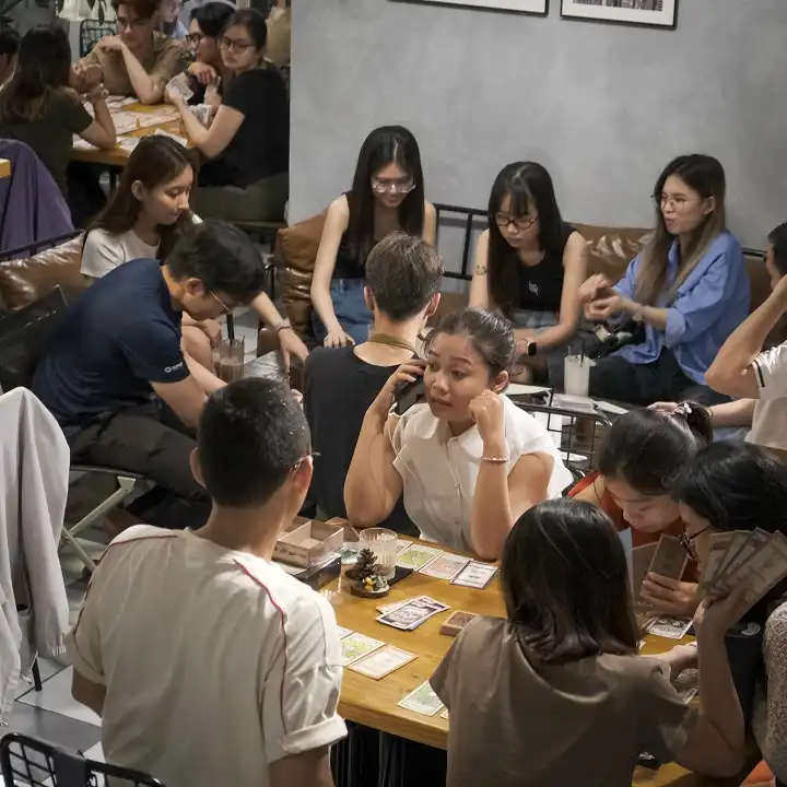 Friends playing board game at Arata